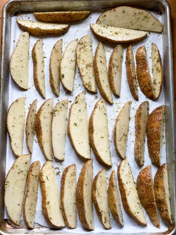 Seasoned potatoes on sheet pan in single layer.