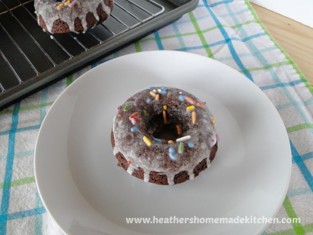 Chocolate Sour Cream Baked Donuts on with sprinkles on white plate. 