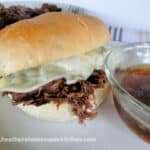 Instant Pot Drip Beef Sandwiches with melted cheese and bowl of au jus