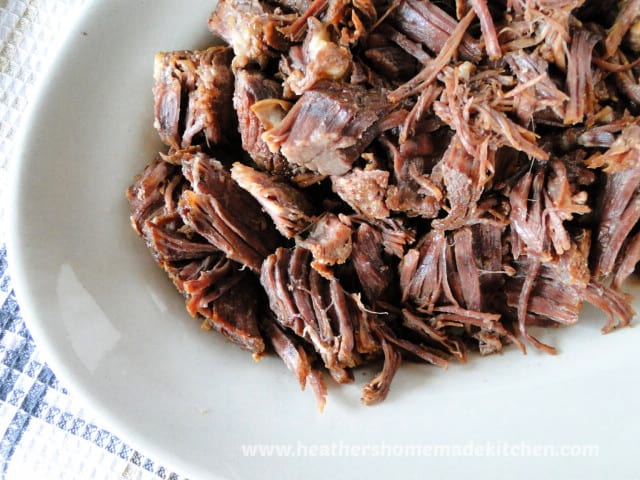 Shredded beef on platter for Instant Pot Drip Beef Sandwiches