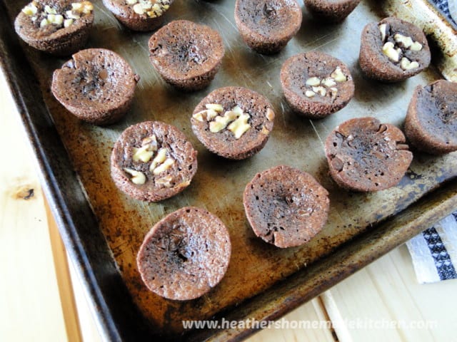 Homemade Brownie Bites in rows on sheet pan, half with walnuts. 