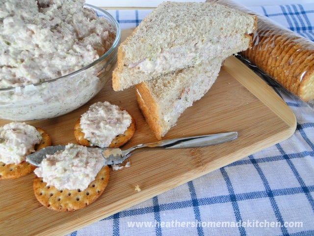 Easy Ham Salad in glass bowl, in between sliced bread, and on a cracker with spreader. 
