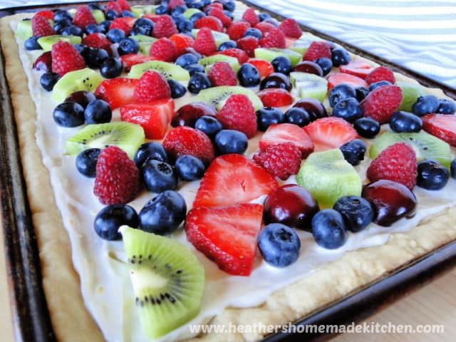 Fresh Fruit Pizza front view with kiwi, blueberries, strawberries on cookie crust and lemon spread. 