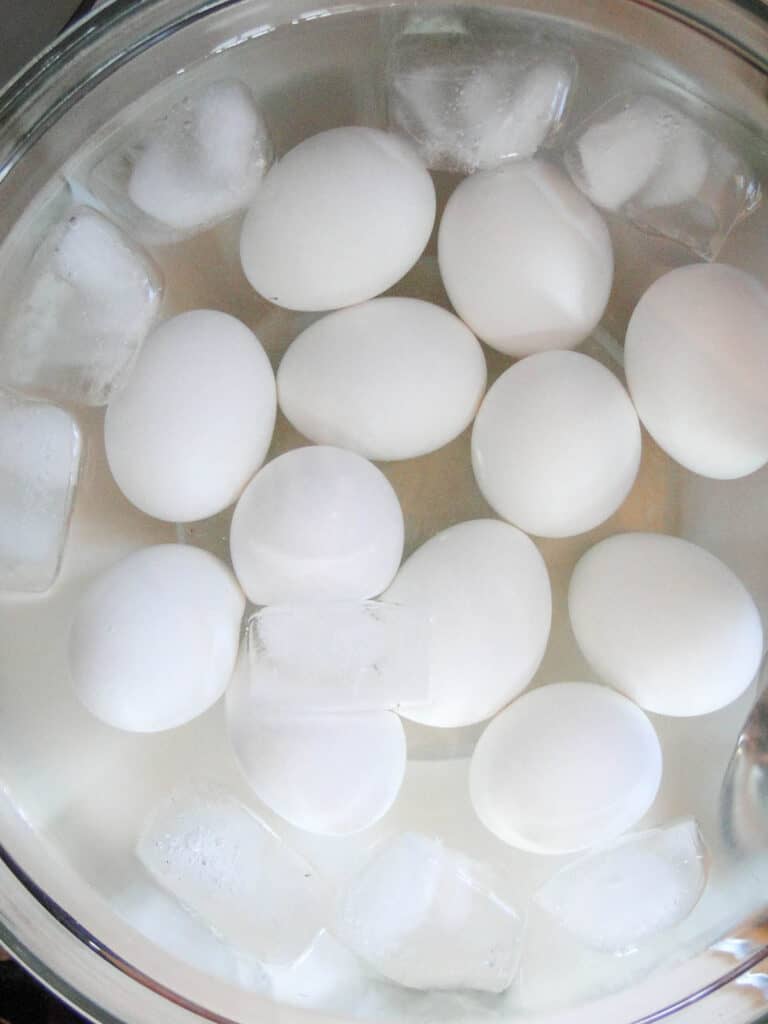 Instant pot hard boiled eggs in glass bowl of ice water.