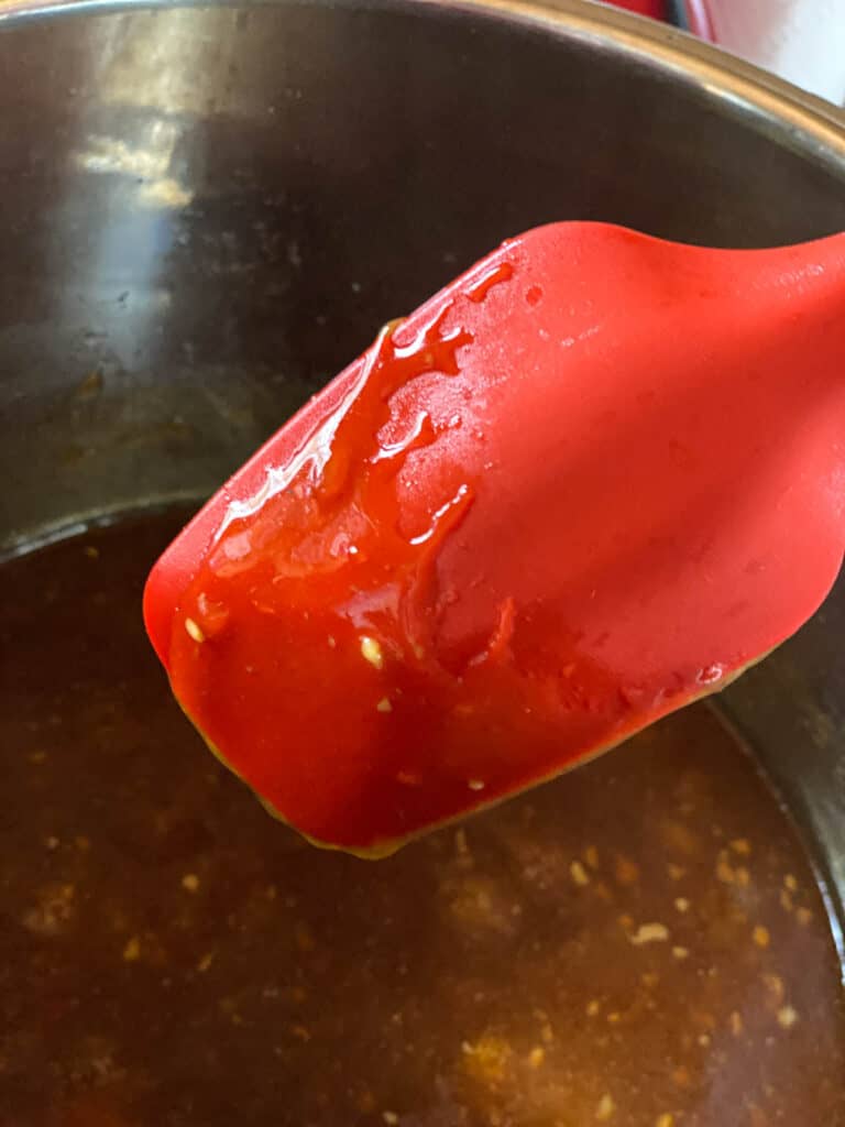 Thickened teriyaki sauce coated the back of a red spoon.