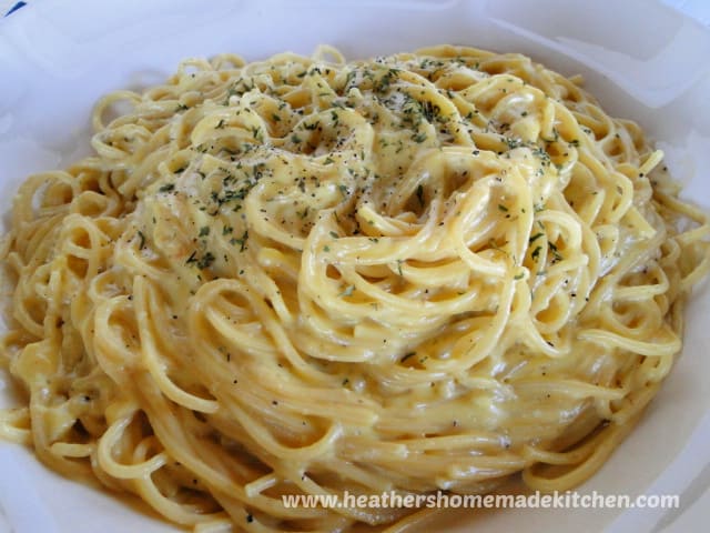 Front view of large white bowl of Classic Spaghetti Carbonara with parsley and black pepper on top of pasta.