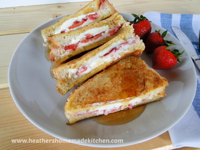 Front view of Strawberries & Cream Stuffed French Toast cut in half and drizzled with syrup.