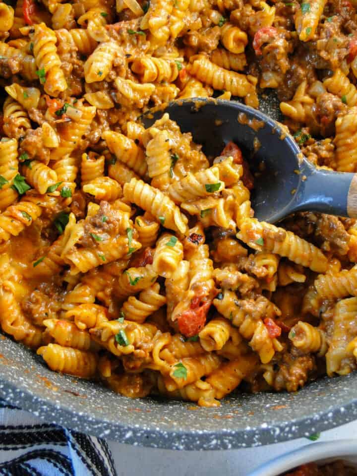 Taco pasta skillet in round skillet with serving spoon.