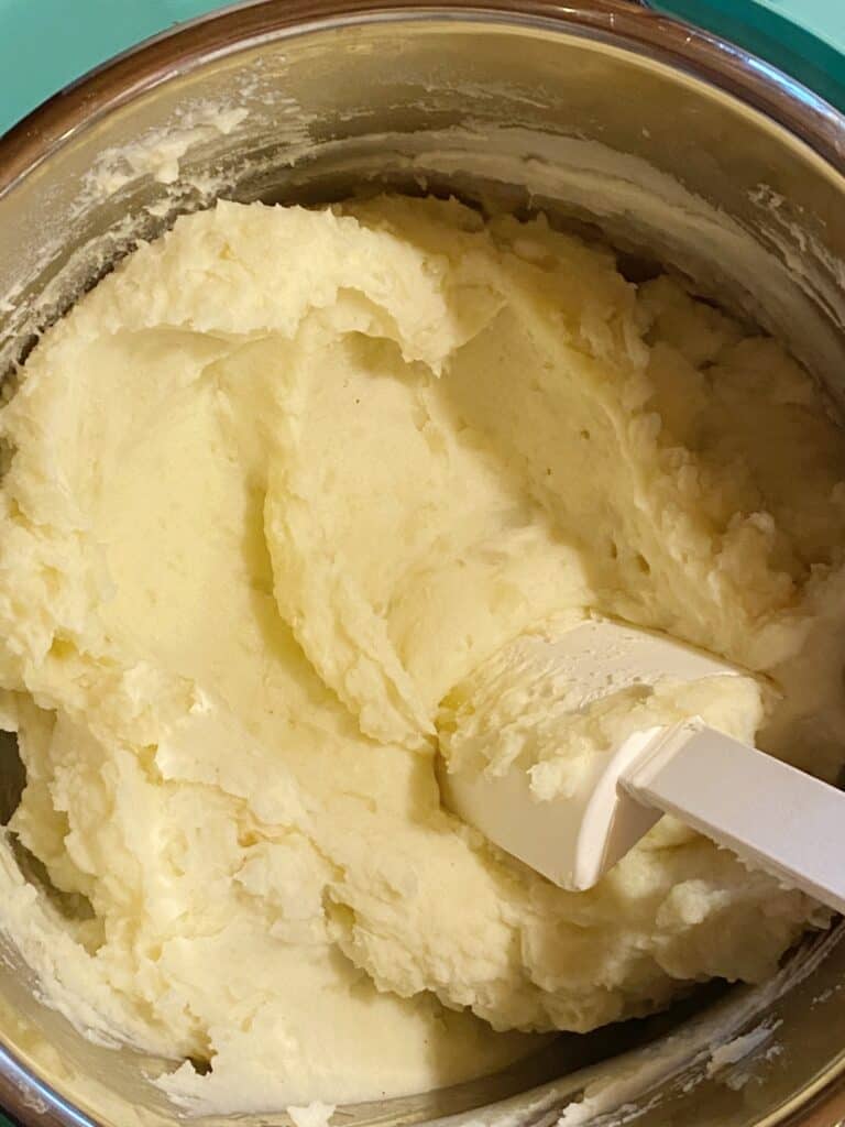 Mashed potatoes in the instant completely mixed with white spatula.