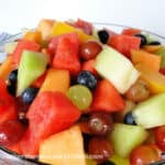 Summer Fruit Salad in clear glass bowl side view.