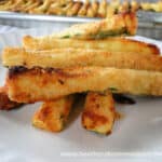 Air Fryer Zucchini Fries in a pile on white plate.