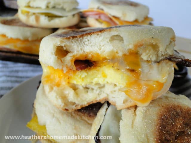 Freezer Breakfast Sandwiches piled on plate with bite taken out of top one.