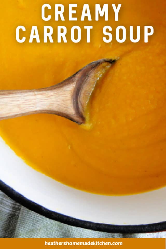 Top View of Creamy Carrot Soup in large pot with wooden spoon.