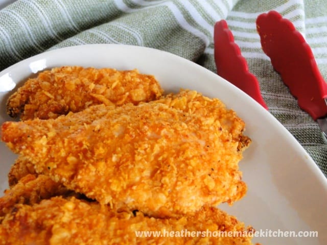 corn flake chicken tenders on platter with tongs