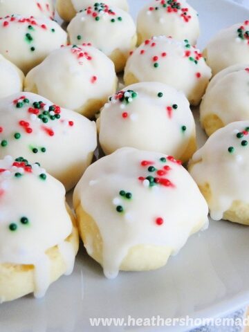Italian Almond Cookies with green and red sprinkles on white round cookie plate