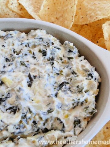 Crock Pot Spinach Artichoke Dip in oval baker with tortilla chips.