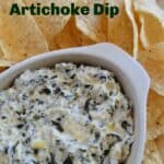 Crock Pot Spinach Artichoke Dip in oval dish surrounded by tortilla chips.