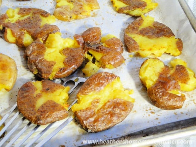Smashed Potatoes with metal spatula.