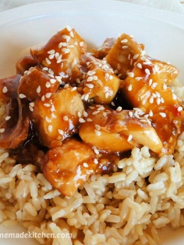 Side view of instant pot honey garlic chicken over rice with sesame seeds on top.