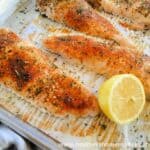 Simple Roasted Chicken Breasts on sheet pan with lemon half.