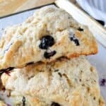 Side view of blueberry scones with golden edges stacked on sheet pan.