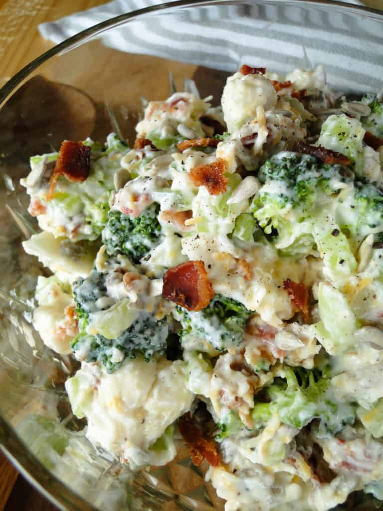 Close up view of broccoli cauliflower salad in glass bowl.