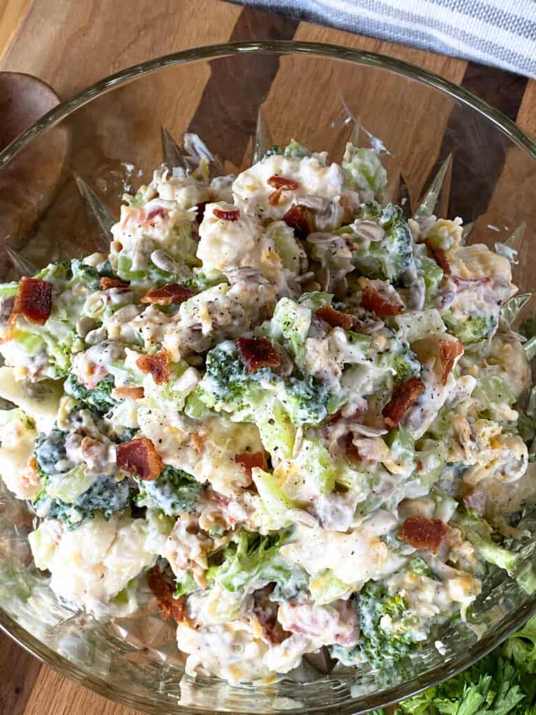 Top view of broccoli and cauliflower salad in glass bowl.