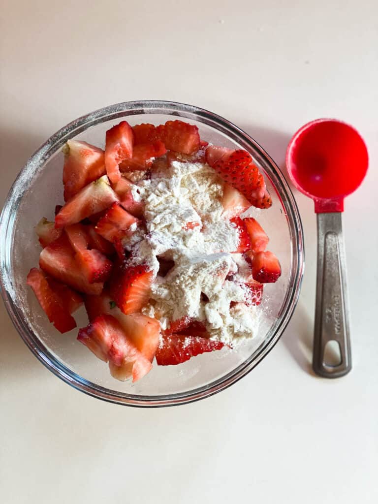 Strawberries in bowl with flour.