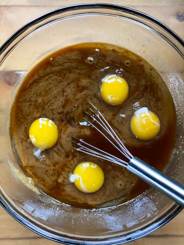 Eggs being added to butterscotch and sugar.