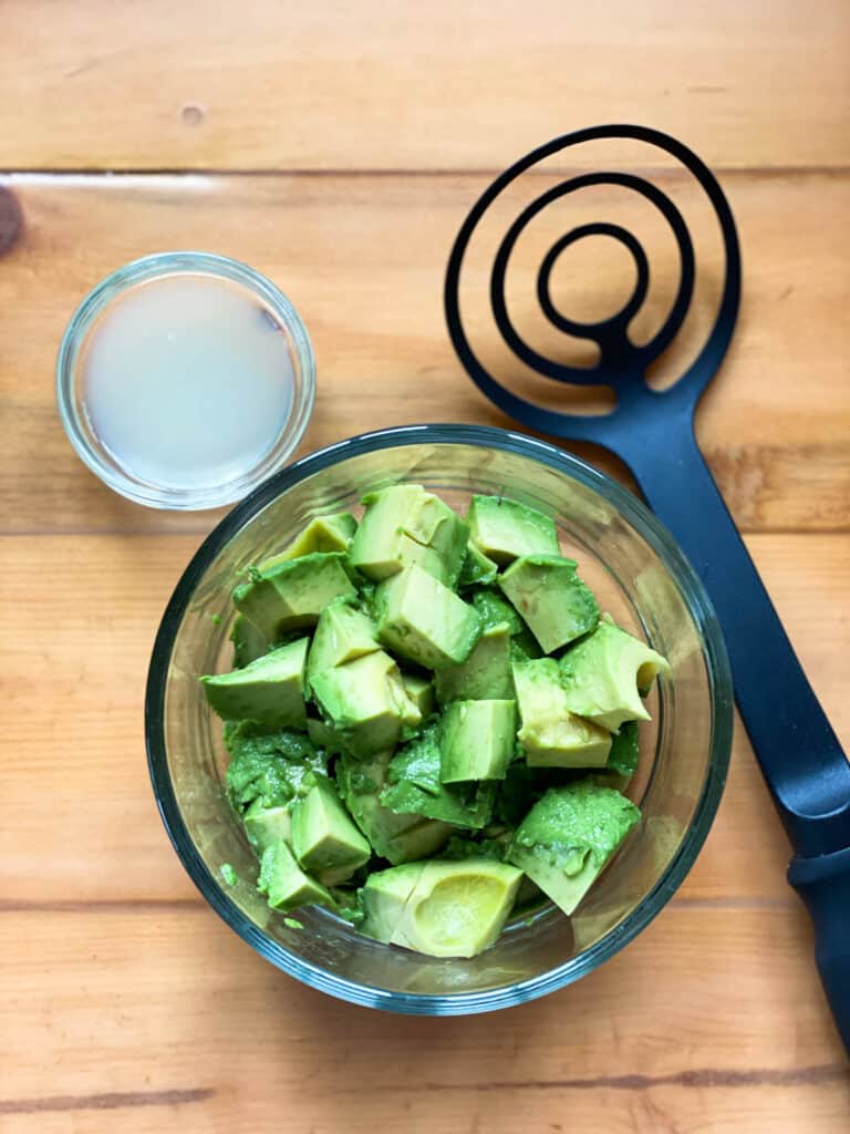 Avocados and lemon juice in glass bowls.