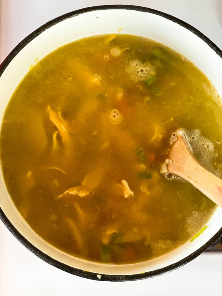 Chicken soup simmering without noodles.