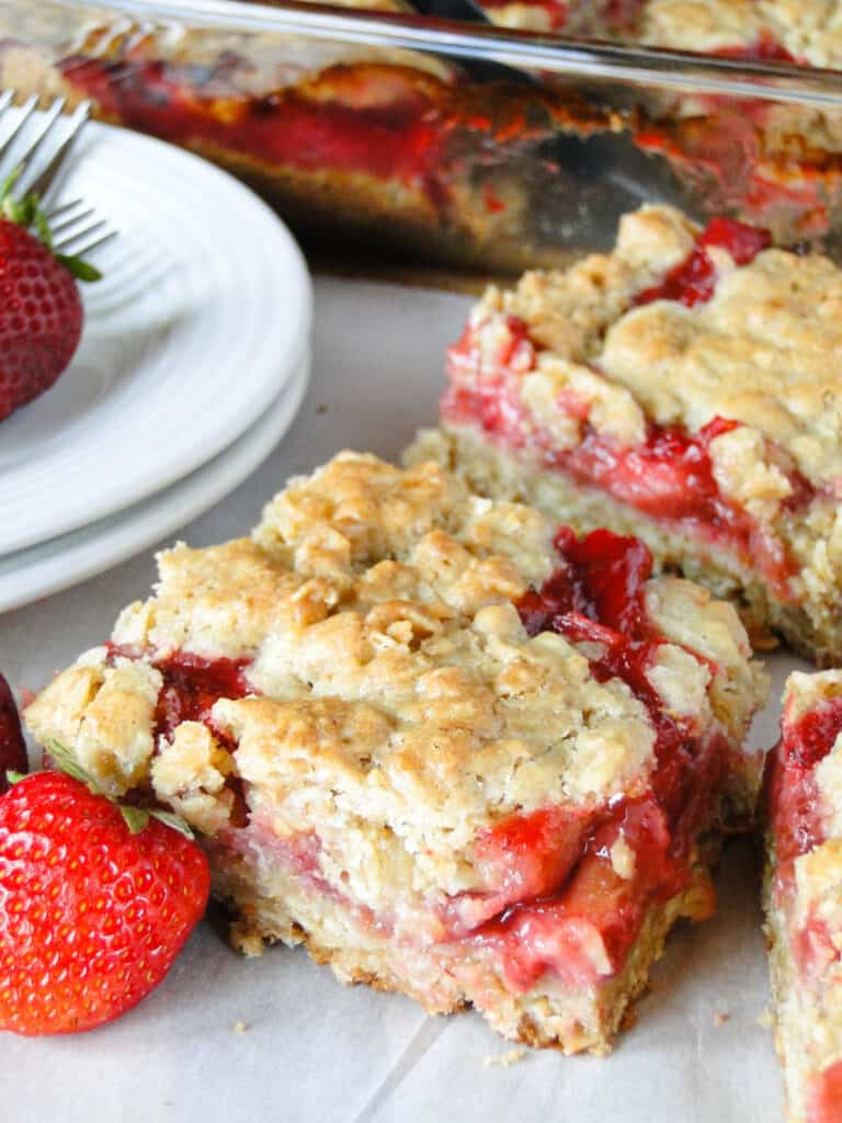 Close up view of strawberry rhubarb bars sliced into squares.