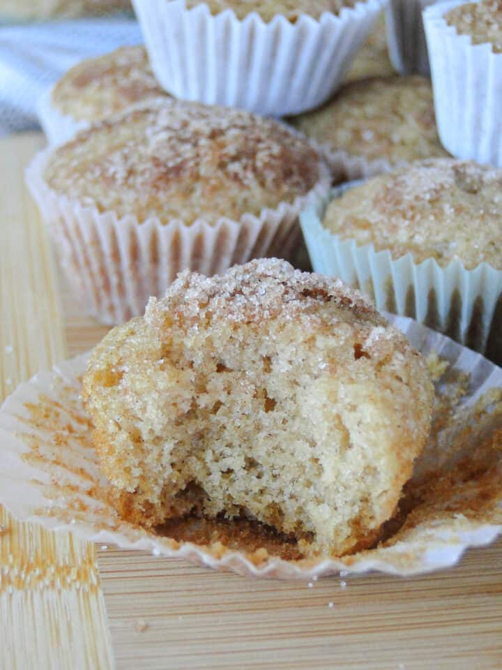 Close up view of applesauce mini muffin with a bite taken out showing center of muffin.