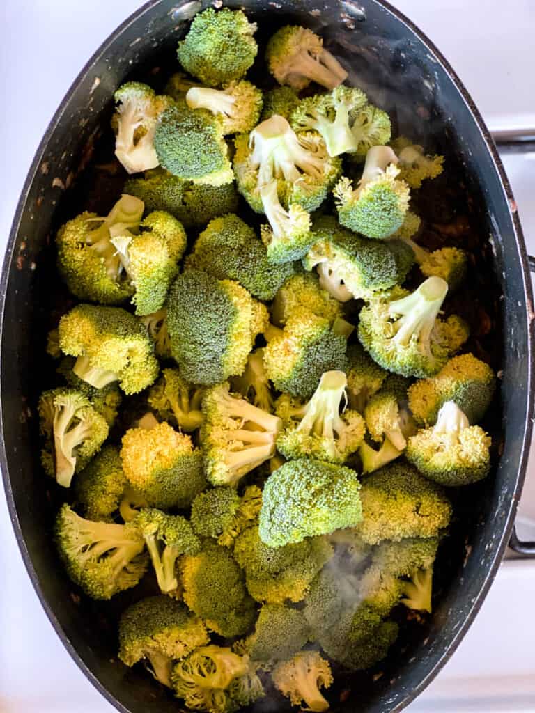 Broccoli sauteeing in pan.