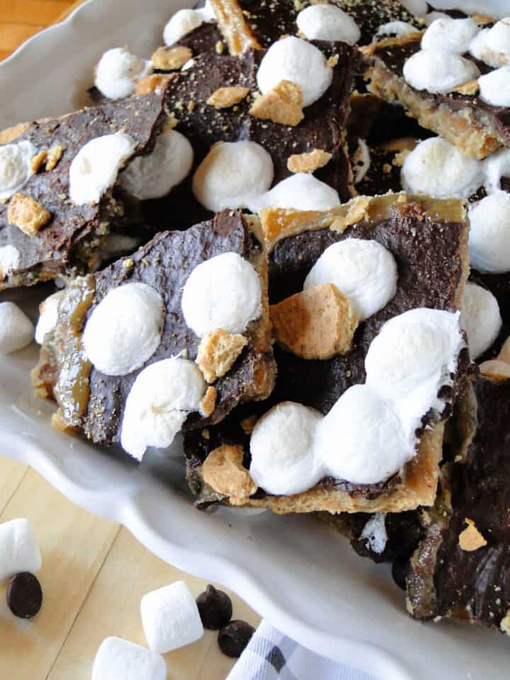 Close up view of broken pieces of s'mores cracker toffee on white platter.