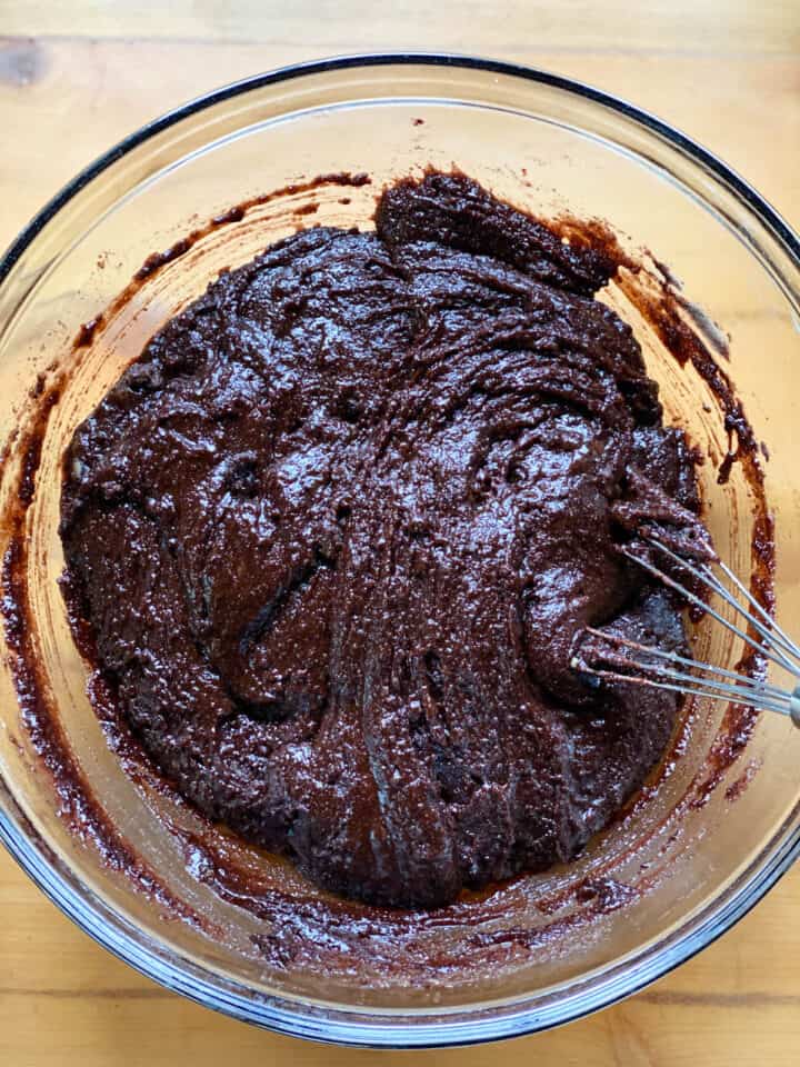 Completely mixed brownie batter in large glass bowl with whisk.