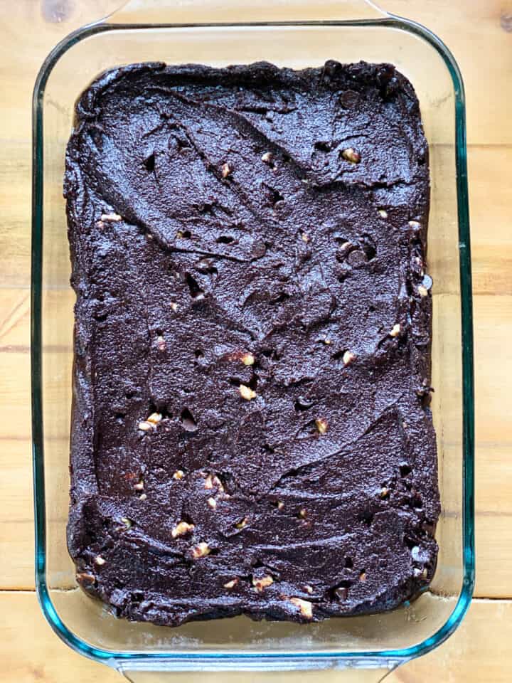 Brownie batter spread into a 9x13 glass baking dish.
