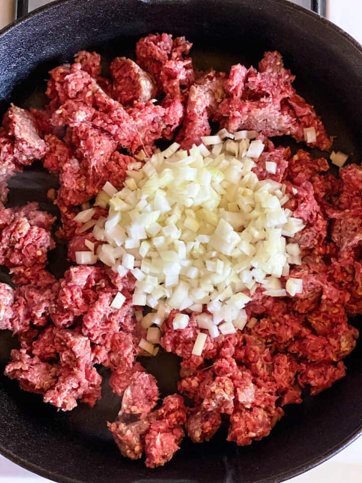 Ground beef and onions in skillet.