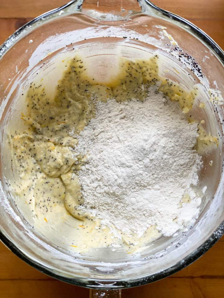 Flour added to muffin batter in large glass bowl.