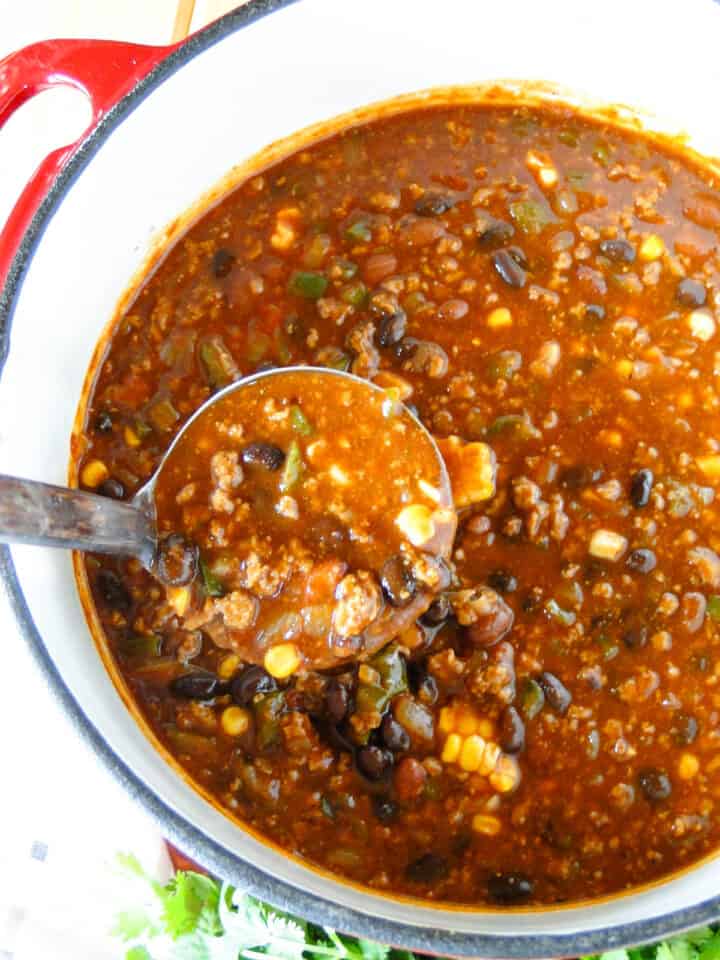 Ladleful of ground turkey chili from the soup pot.