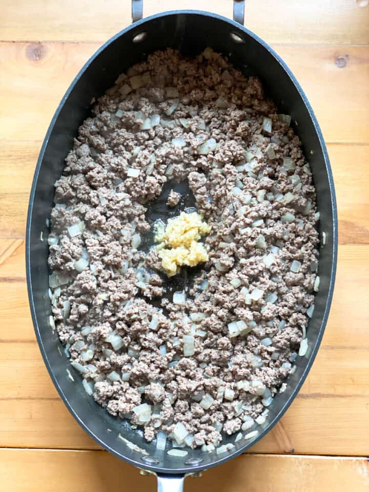 Cooked ground beef and onions with garlic added.