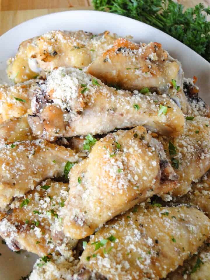 Close up of crock pot garlic parmesan chicken wings on platter.