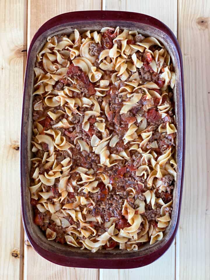 Mixed pasta, beef and sauce added to casserole dish.