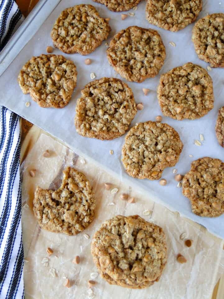Oatmeal scotchies on cookie sheet with some cookies off to the side.