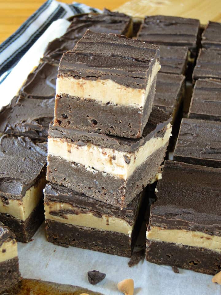 Peanut butter brownie bars sliced and stacked 3 high next to more bars.