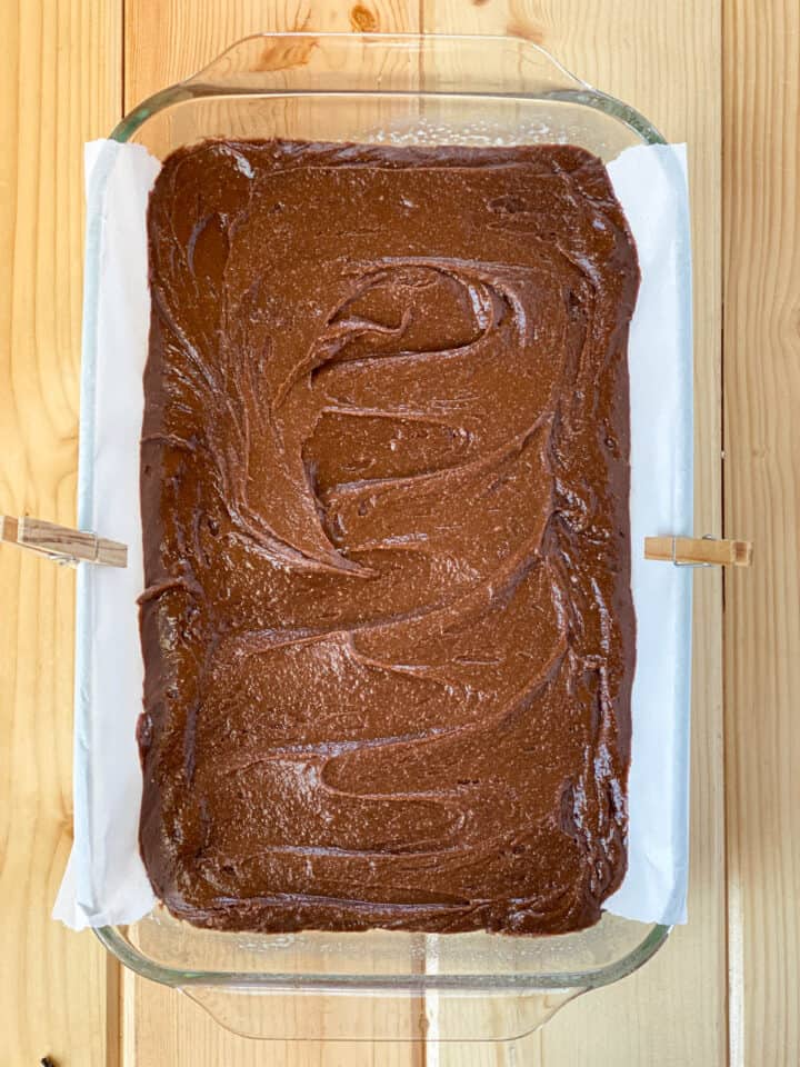 Brownie batter spread evenly into baking dish.