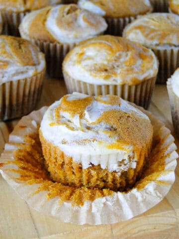 Side view of pumpkin cream cheese muffin with paper liner off showing muffin.