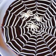 Close top view of spiderweb brownies on white round cake plate.