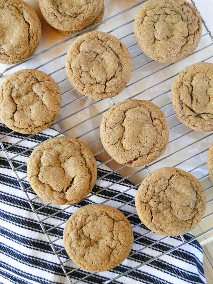 Chewy molasses cookies in rows on wire rack.