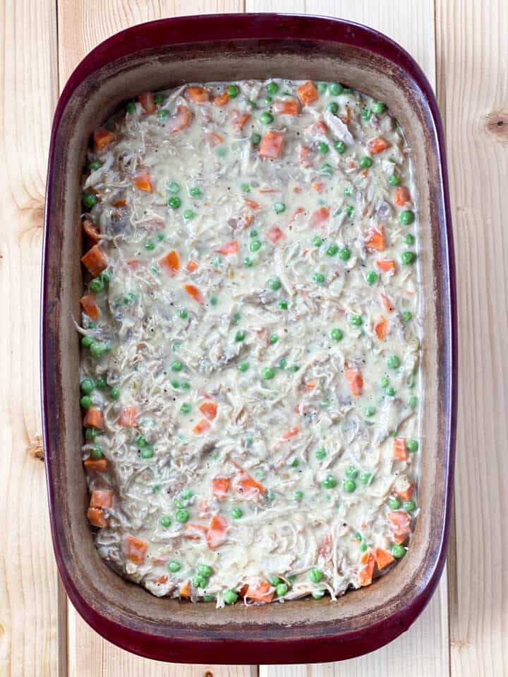 Pot pie filling added to rectangle casserole dish.